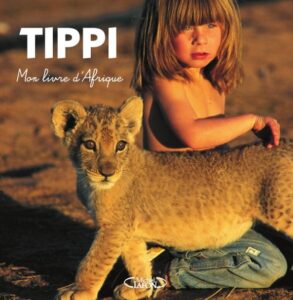 Couverture du livre Tippi, mon livre d'Afrique montrant une enfant avec un lionceau.