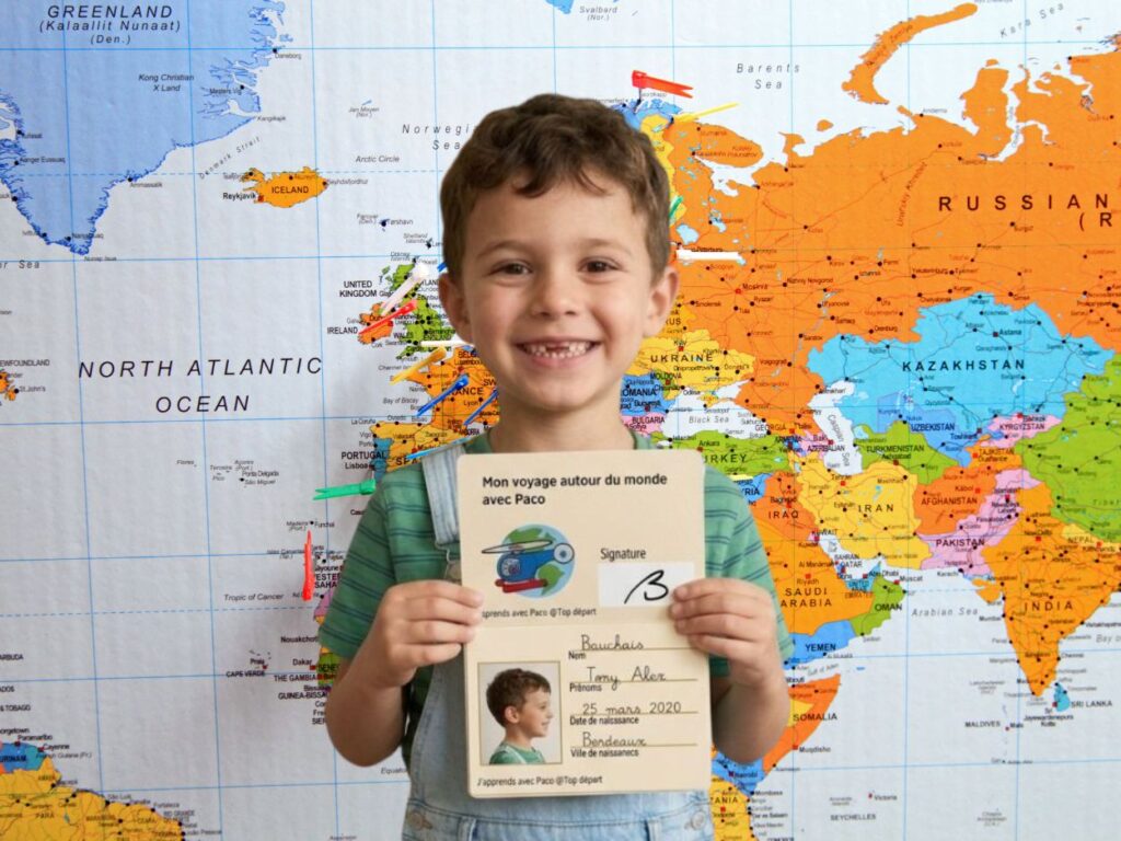 Garçon avec son passeport de découverte des continents devant une carte
