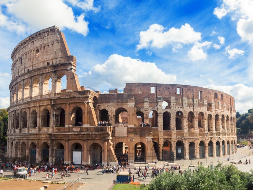 Le Colisée de Rome sous un ciel ensoleillé avec des touristes.