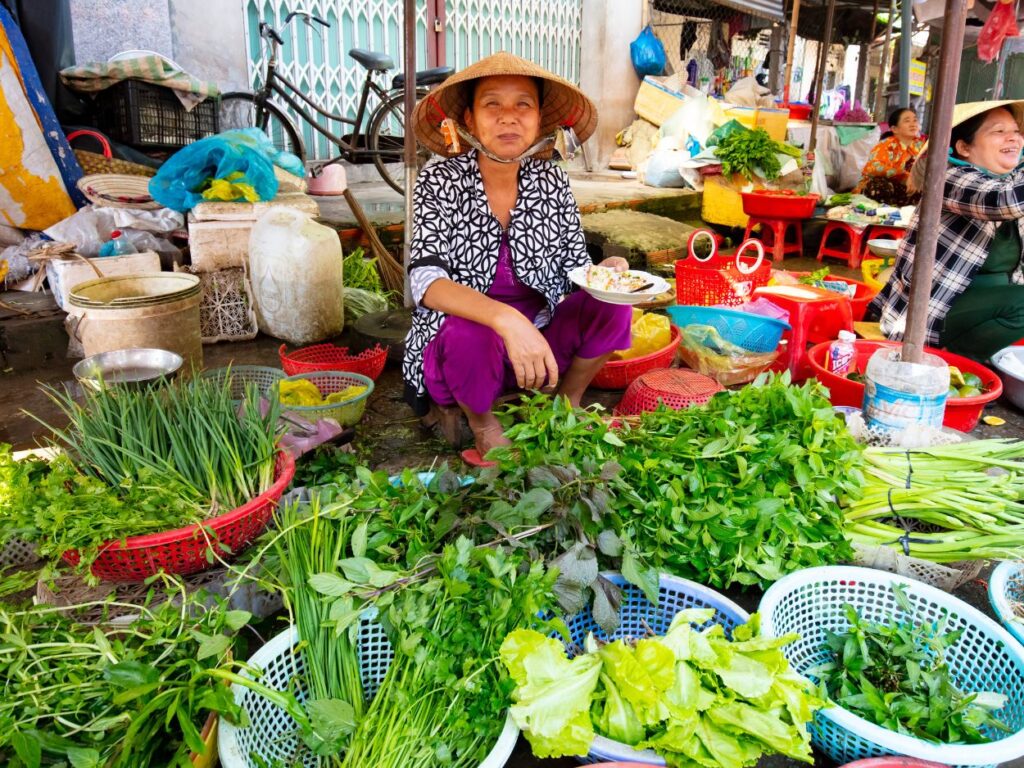Marché traditionnel avec étals de légumes frais et habitante locale