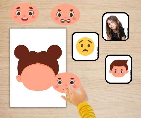 Mains d'enfant manipulant des cartes de visages représentant différentes émotions lors d'une activité de mimes en maternelle